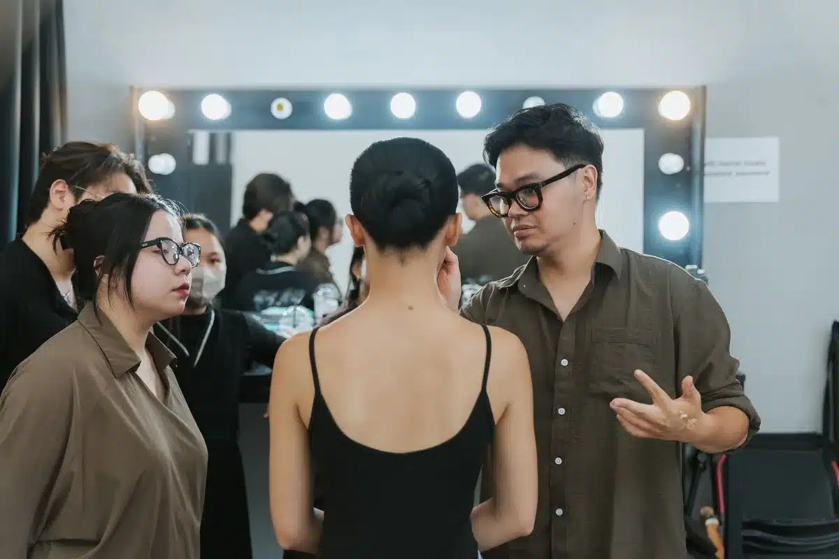 Maquilleur travaillant en coulisses lors d'un d&eacute;fil&eacute; de mode