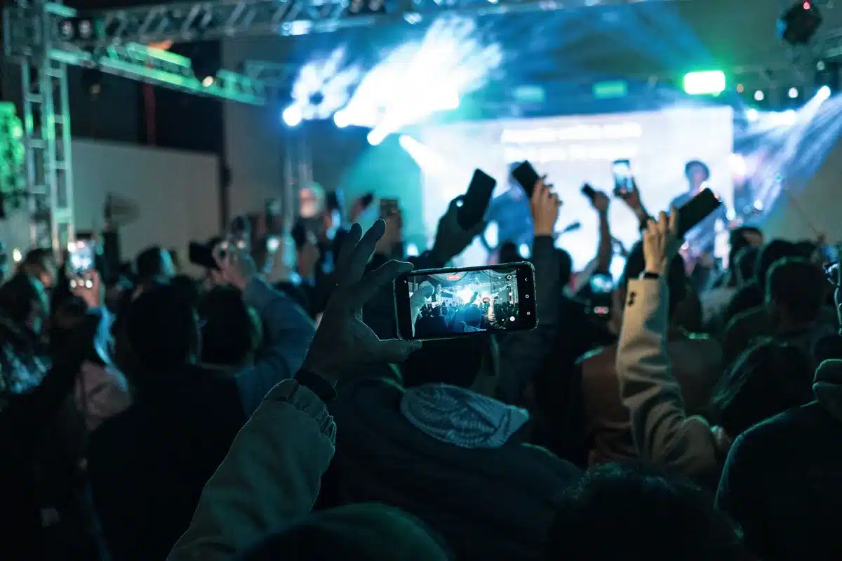 Foule de fans interagissant sur les r&eacute;seaux sociaux, partageant leurs chansons pr&eacute;f&eacute;r&eacute;es