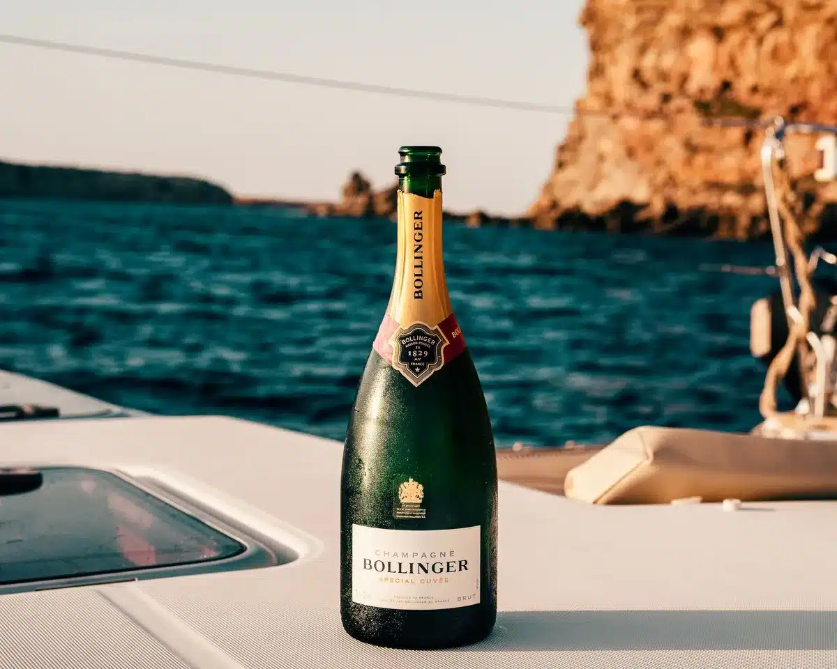 Rooftop party scene with sunset views overlooking Mediterranean waters and yacht silhouettes