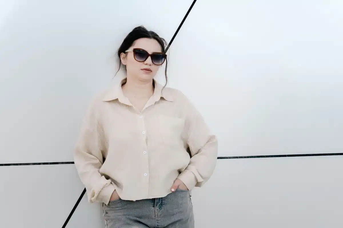 Effortless resort-style outfit with silk slip, oversized linen shirt, and statement sunglasses on beach