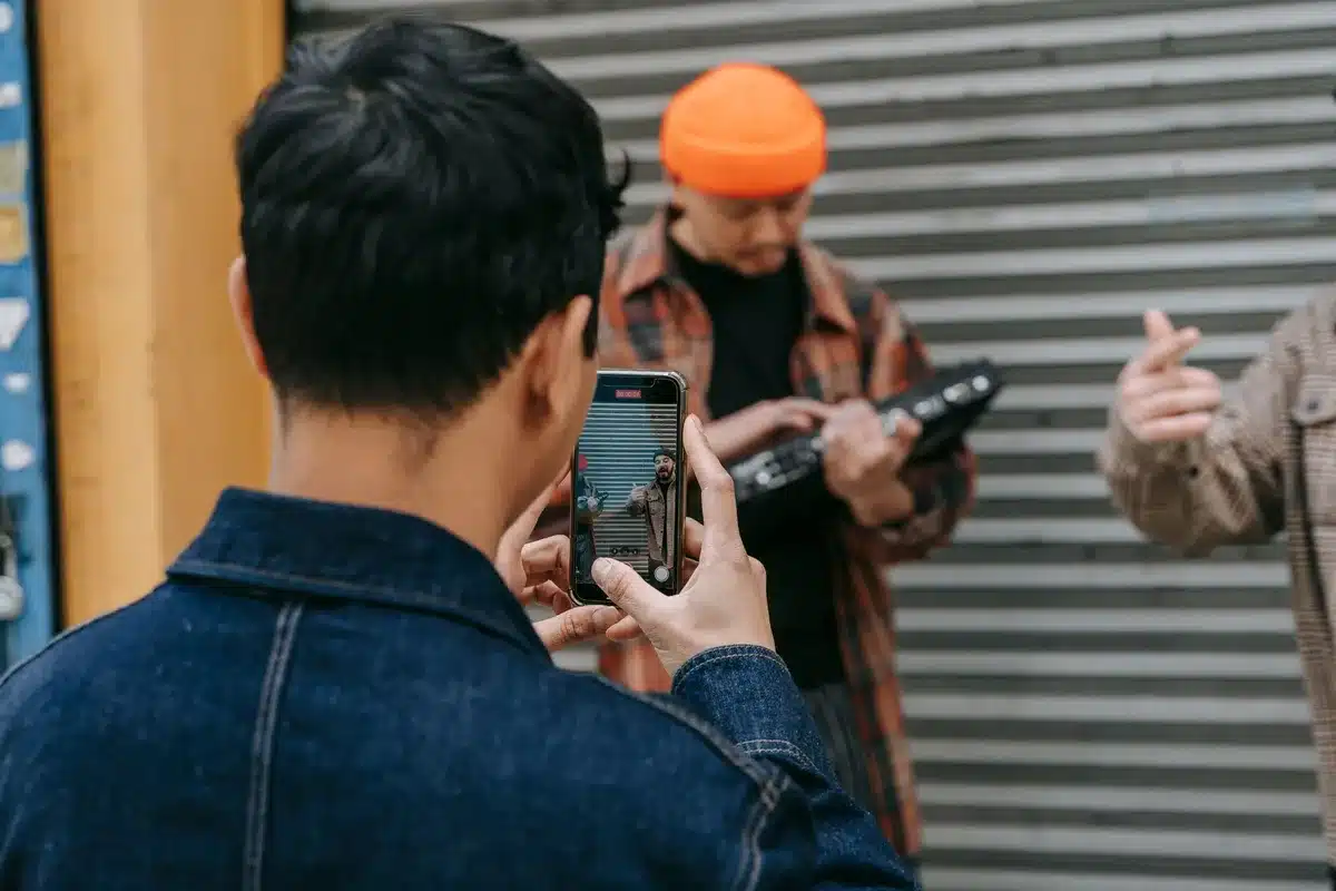 Mano sosteniendo un teléfono inteligente capturando una foto en una multitud urbana