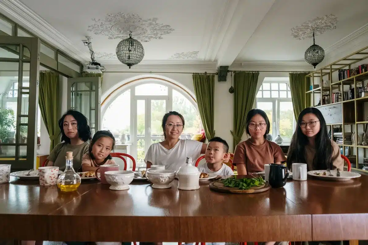 Eine Familie verschiedener Altersgruppen sitzt zusammen beim Abendessen und lacht