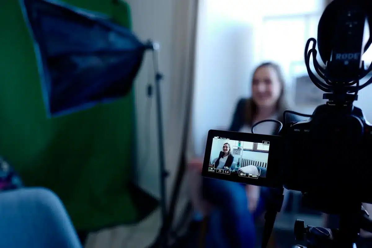 Une influenceuse filmant un vlog avec une expression réfléchie et sincère