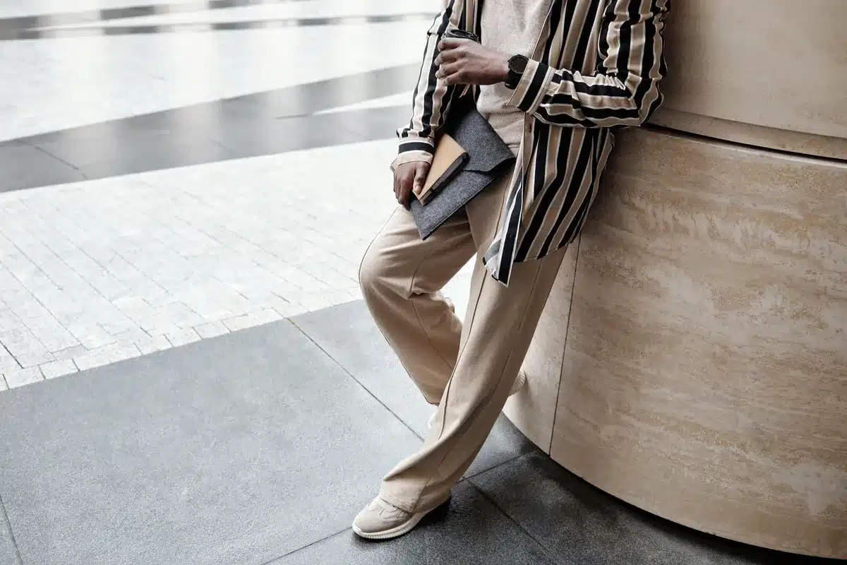 Person wearing relaxed tailoring and streetwear pieces on an urban street