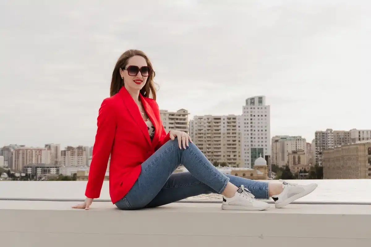 Person wearing lightweight blazer, tailored joggers, chunky sneakers and structured tote bag