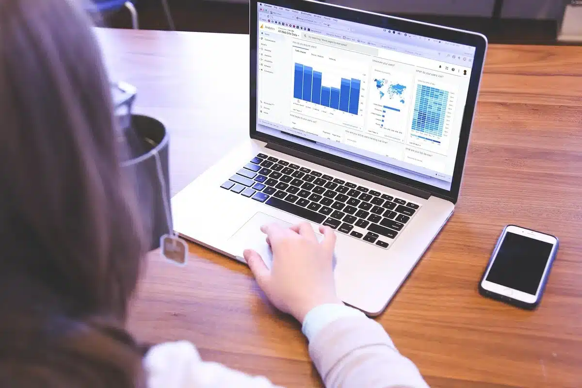 Website editor working at a desk with article drafts and a laptop