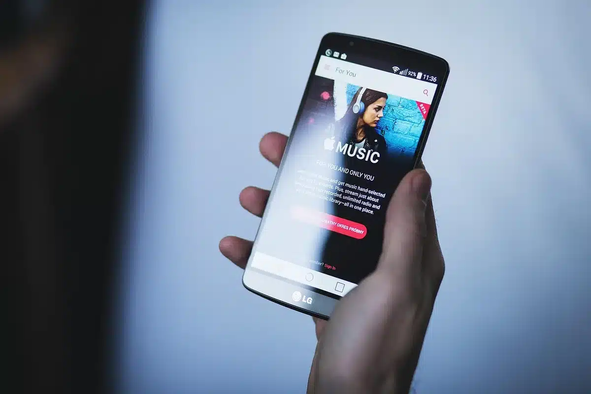 Hands holding a smartphone while refreshing an app feed in daylight