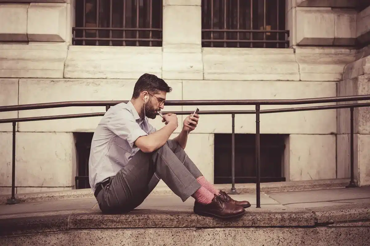 Influencer recording a long video on smartphone in a bright room with large windows