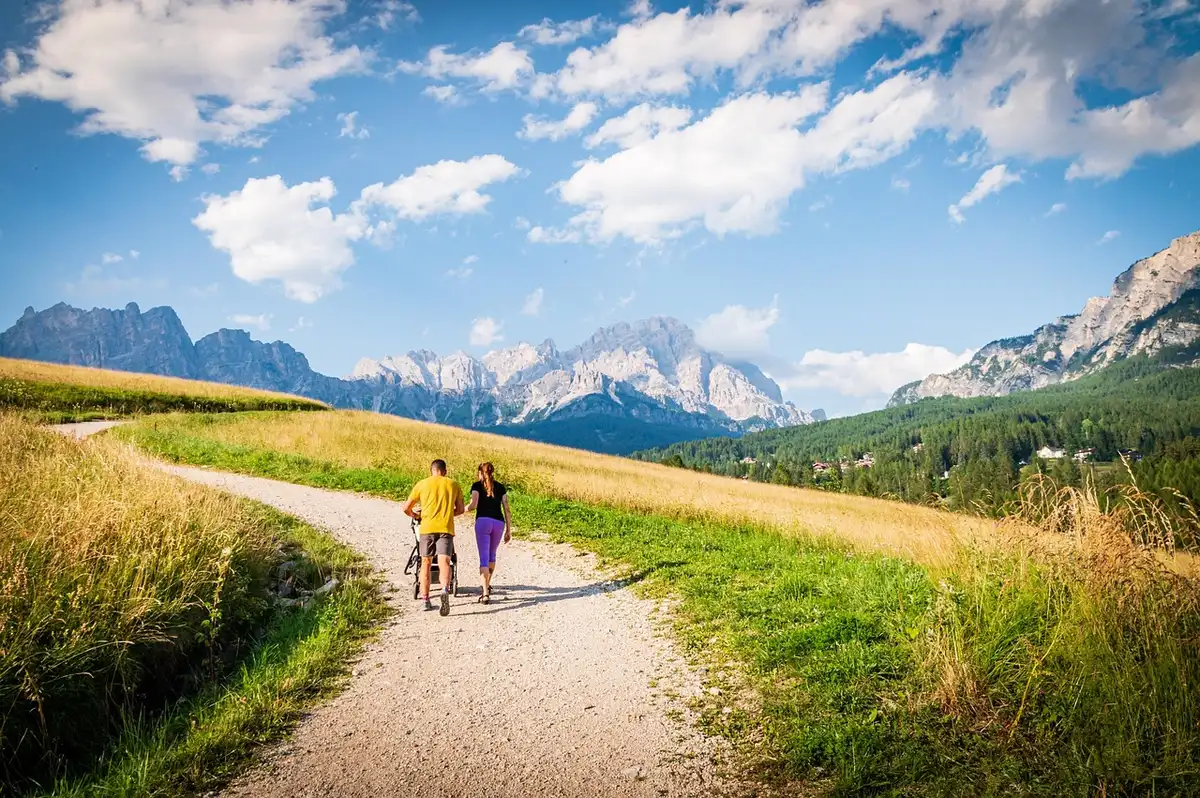 Parents walking with a stroller at a sunny neighborhood park