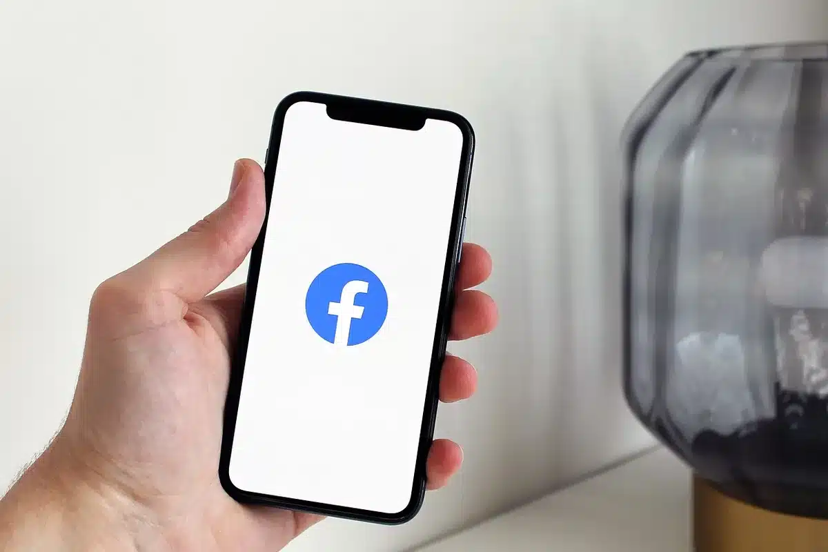 Hand holding phone showing a three-dot menu on an article card in a news feed