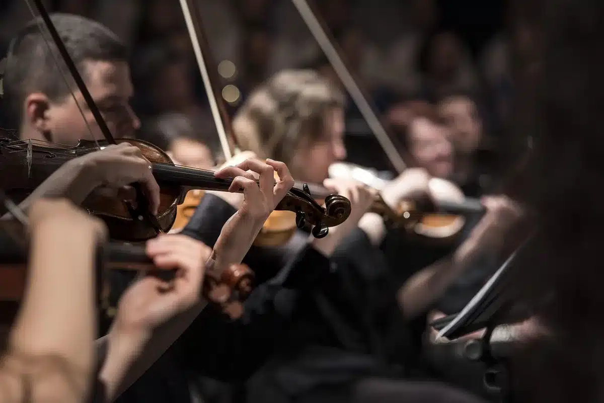 Salle de concert vide avec barrières de sécurité et scène assombrie