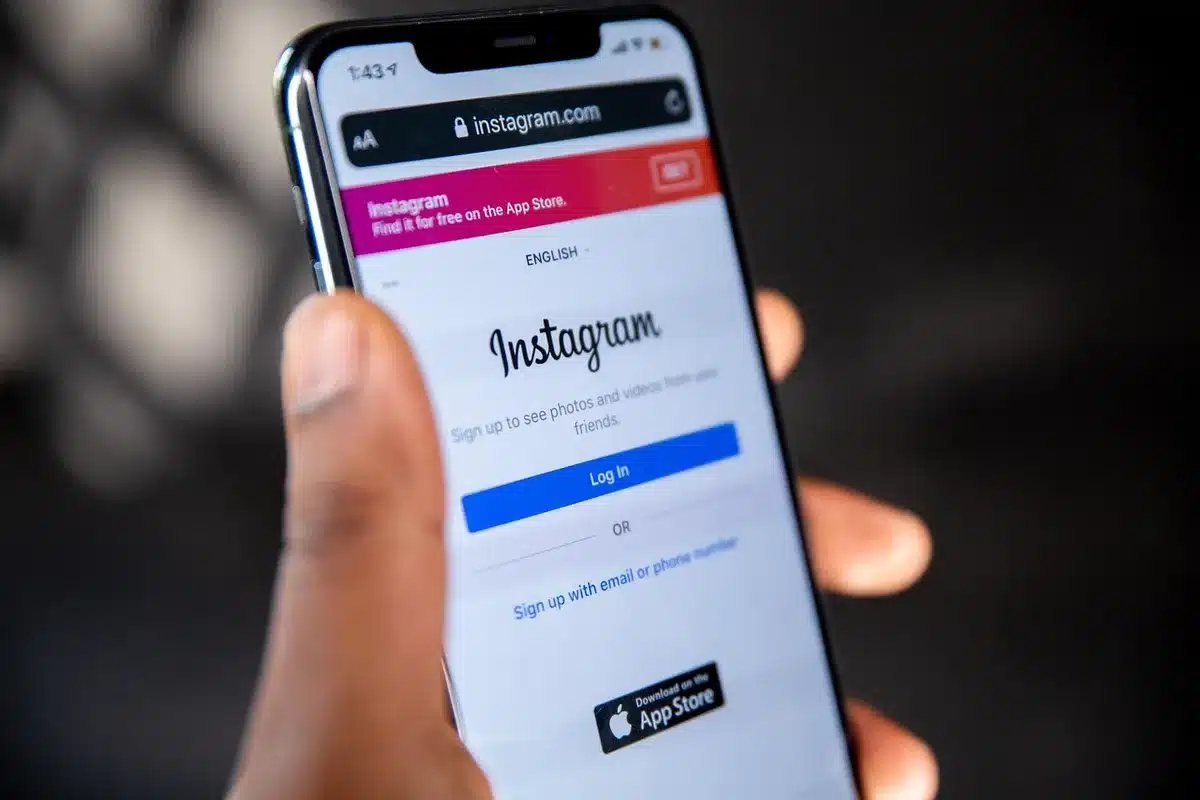 Table de petit-déjeuner inachevé, smartphone montrant des reels flous et une poussette en arrière-plan