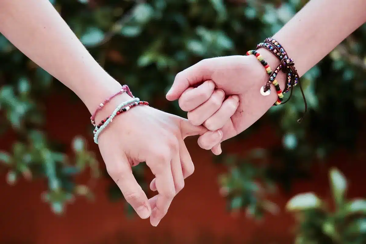 Two actors' hands resting on a table in a sunny rehearsal space