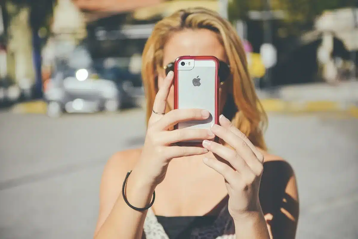 Parent holding a child with camera and phone out of focus in background