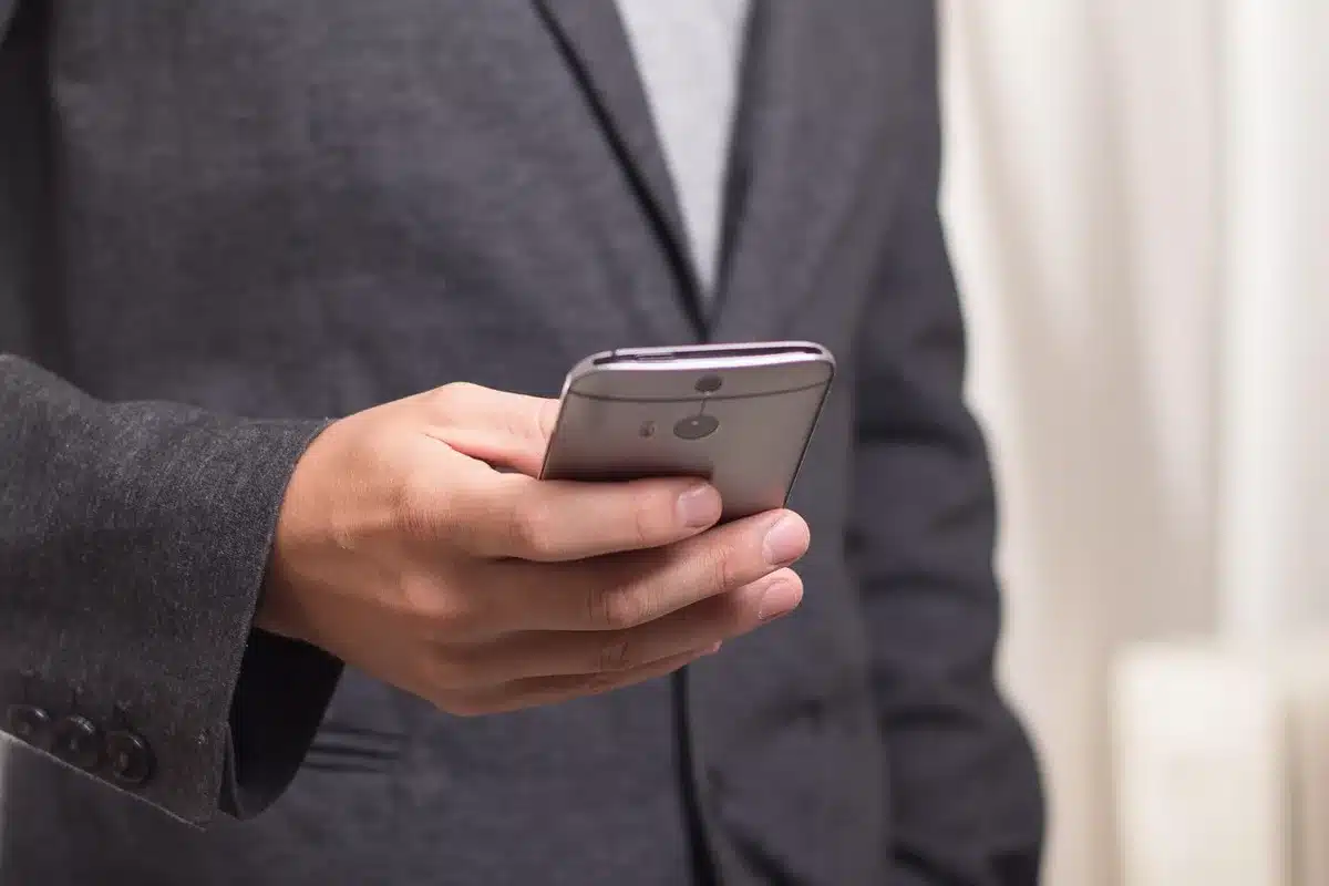 Smartphone screen showing a private messaging group, placed on a table