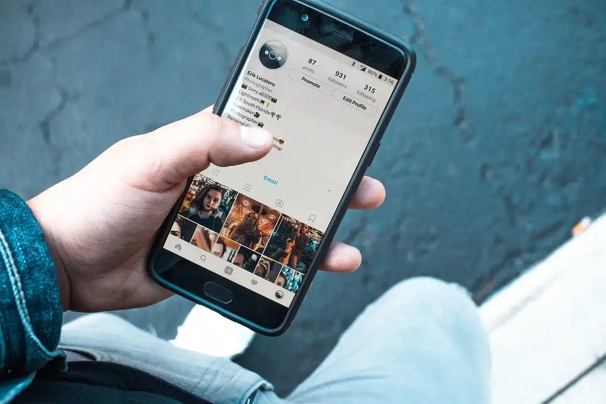 Personne anonymisée regardant des commentaires sur un smartphone en journée