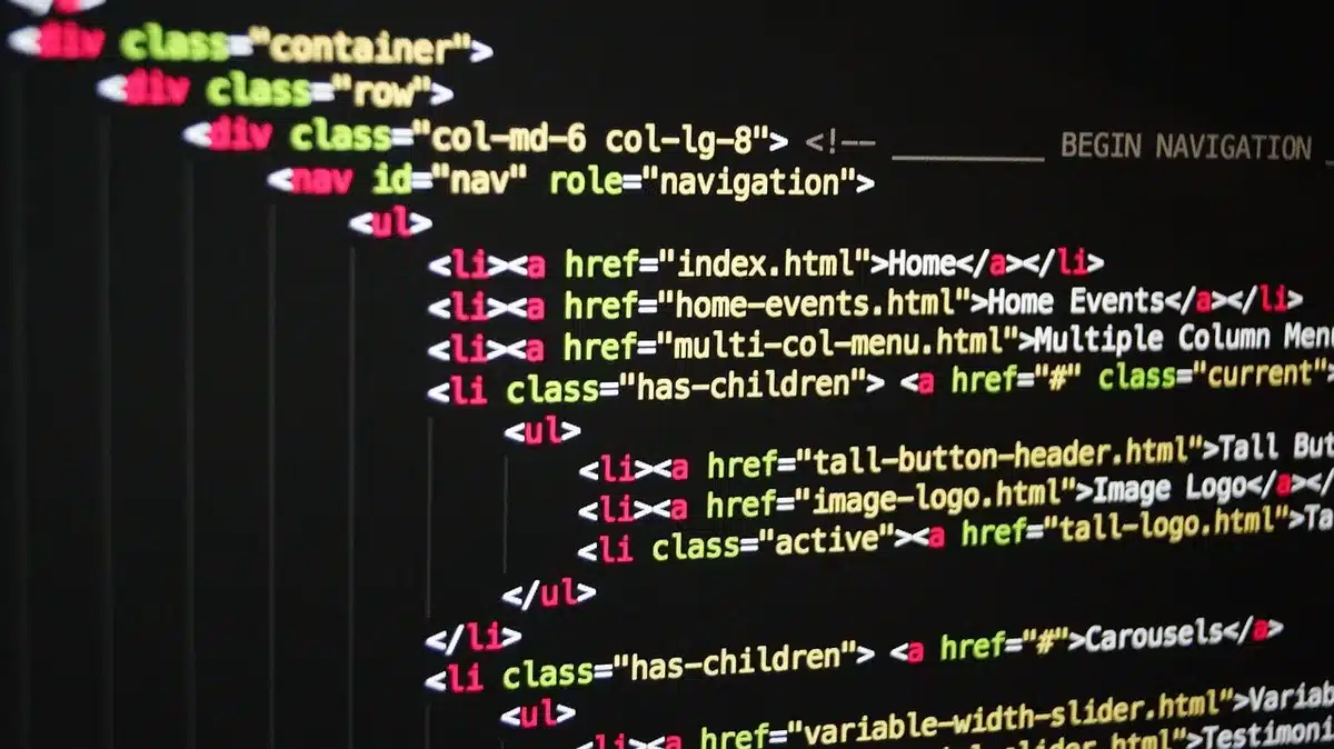 Developer laptop with code and performance charts on screen beside a coffee cup